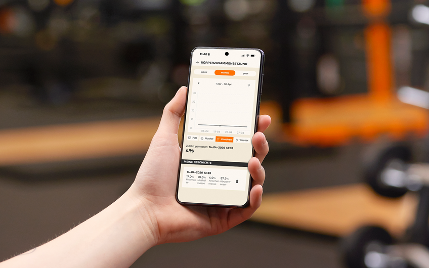 Member viewing bone mass and body composition analysis in the Basic-Fit app during a gym visit.