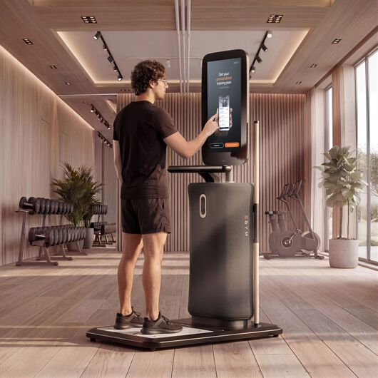 Mann nutzt den Touchscreen einer EGYM-Onboarding-Station, um in einem Fitnessstudio einen personalisierten Trainingsplan einzurichten.