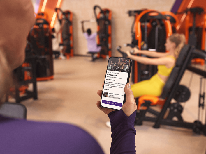 Person, die sich einen Trainingsplan in der Basic-Fit-App ansieht.