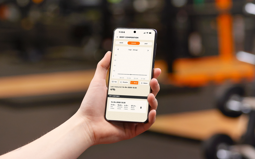 Member viewing bone mass and body composition analysis in the Basic-Fit app during a gym visit.