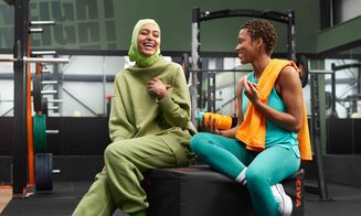 Two girls sitting in a Basic-Fit gym on a jump box