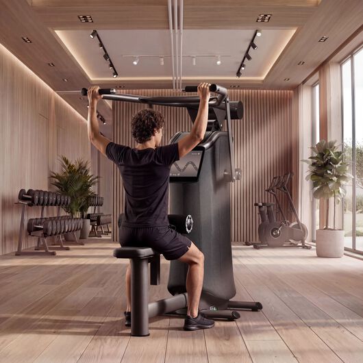 Mann trainiert seinen R&uuml;cken an einem EGYM-Latzugger&auml;t mit gef&uuml;hrtem &Uuml;bungsfeedback auf dem Bildschirm.