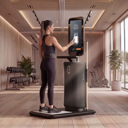Frau nutzt den Touchscreen einer EGYM-Onboarding-Station, um ihren personalisierten Trainingsplan zu erhalten.