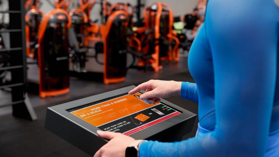 Person, die ihre Ergebnisse auf einem K&ouml;rperanalyseger&auml;t in einem Basic-Fit-Club ansieht.