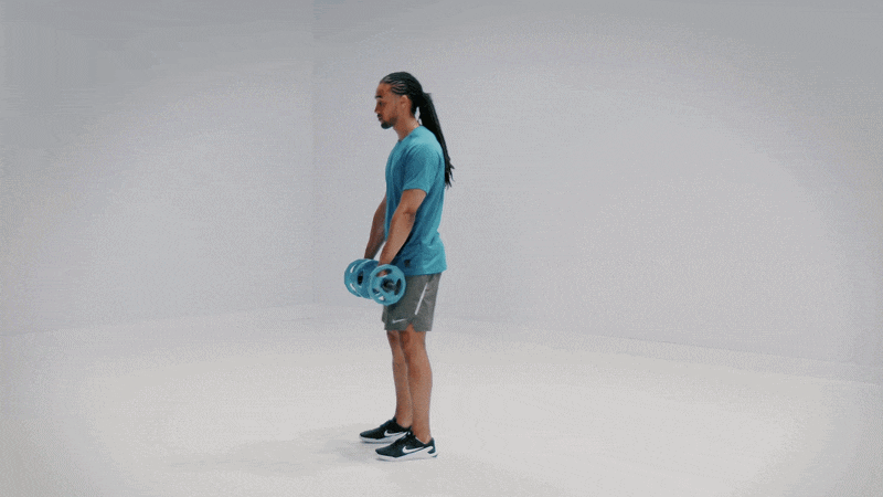 Hombre realiza un remo inclinado con discos en un entorno de estudio