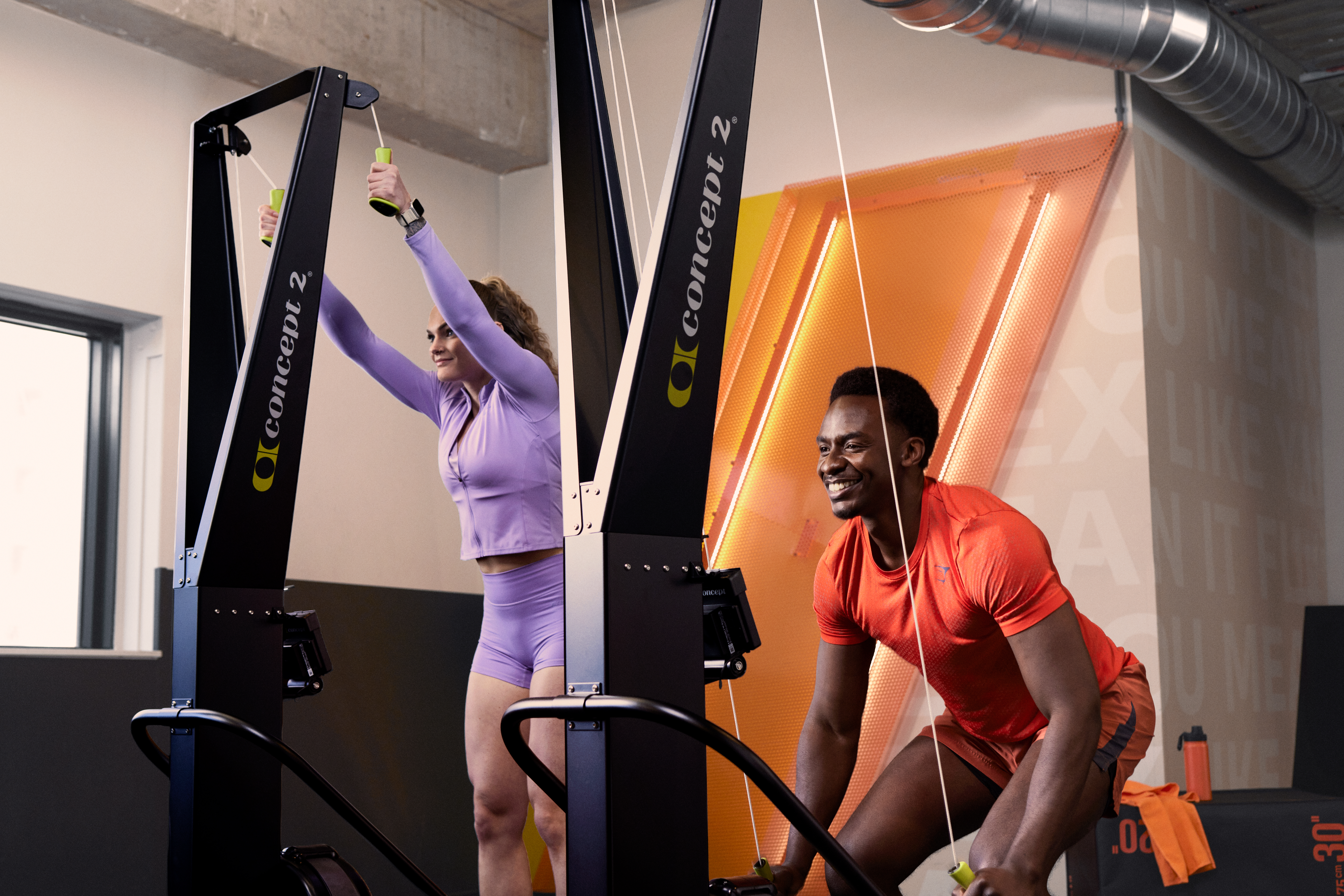 Dos personas entrenando juntas en el SkiErg en Basic-Fit