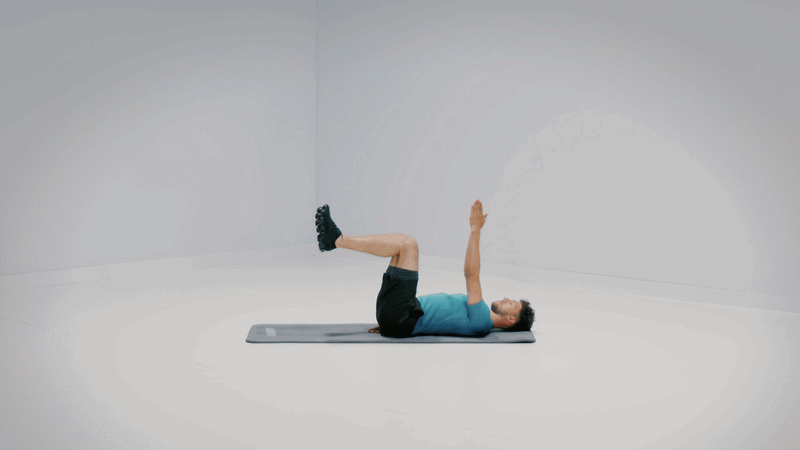 Hombre tumbado boca arriba con las piernas elevadas realizando un ejercicio de core