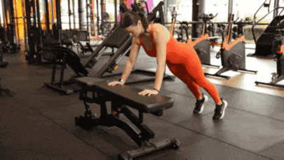 Person performing an incline push-up with hands supported on an elevated surface.